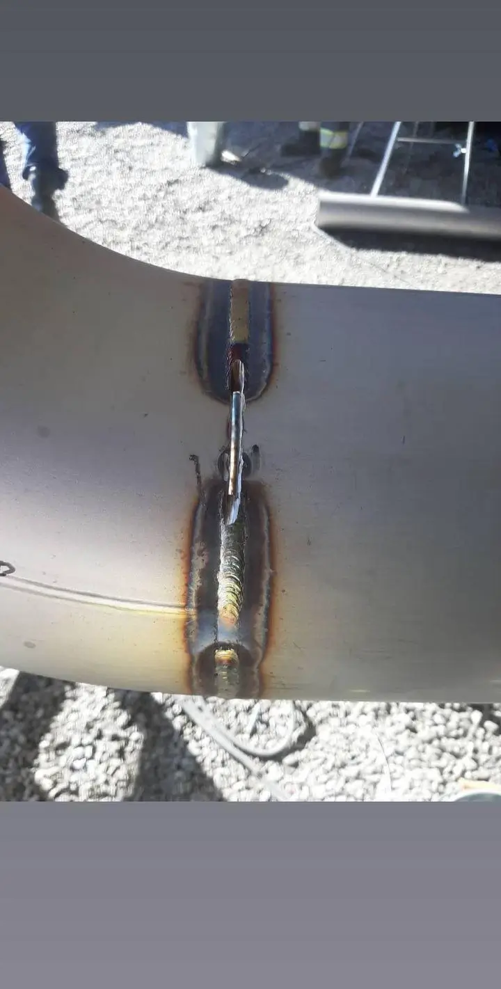 Metalliputki, jossa on hitsattu sauma, ulkona päivänvalossa.